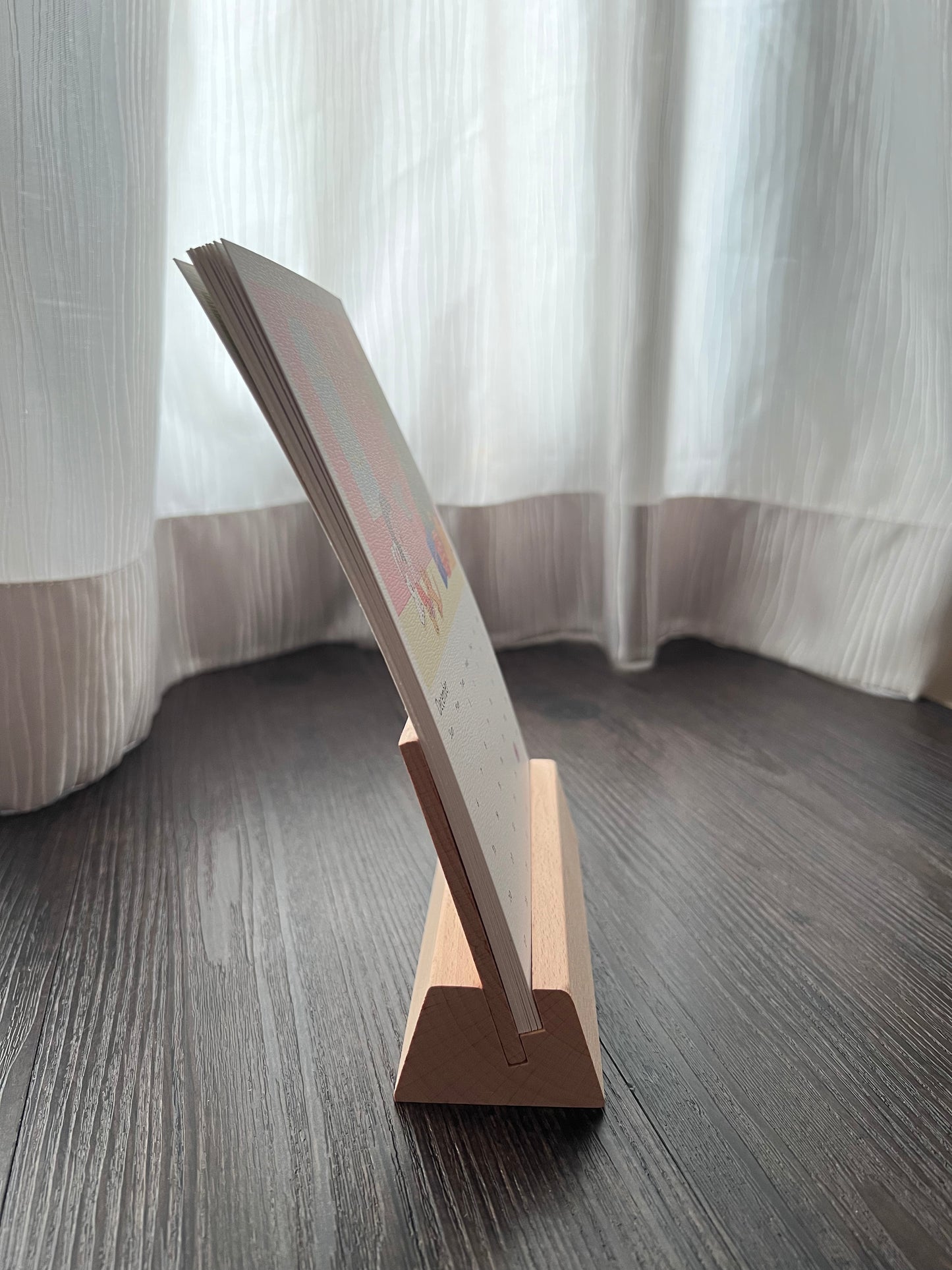 The image shows a side view of the wooden stand with the calendar. The wooden stand has an elevated backing so that the calendar wouldn't bend.