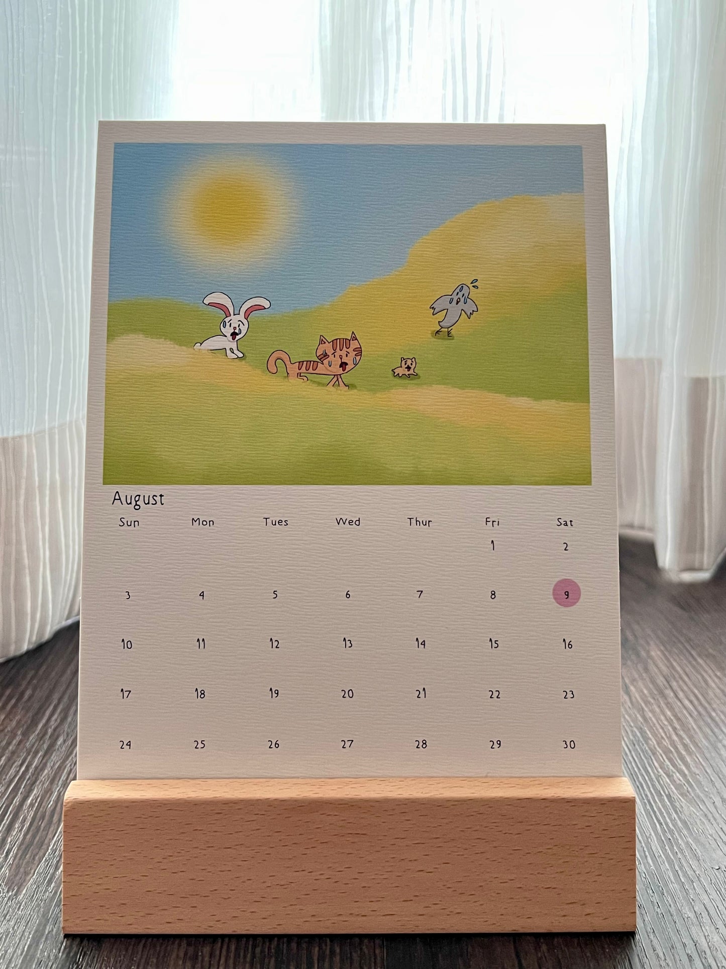 Calendar with drawing of the animal characters sweating and panting because the weather was way too hot. The calendar is placed on the wooden stand