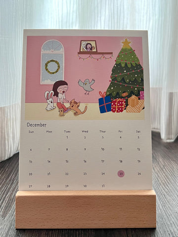 Calendar with Christmas theme, the animal characters are finally went back home to their owner while it's snowing outside. The calendar is placed on the wooden stand. Singpore public holiday is marked in pink