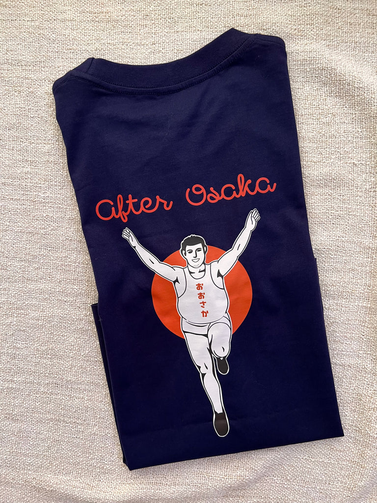 The picture shows the back of a dark blue t-shirt. The illustration is inspired by the famous Glico man in Osaka, with a humourous twist where the Glico man was shown to gain weight after Osaka trip. 