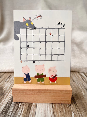 May 2025 calendar inserted in the wooden stand on a desk. The illustration of the May calendar is the tory of 