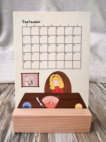 September 2025 calendar inserted in the wooden stand on a desk. The illustration of the September calendar is the story of 