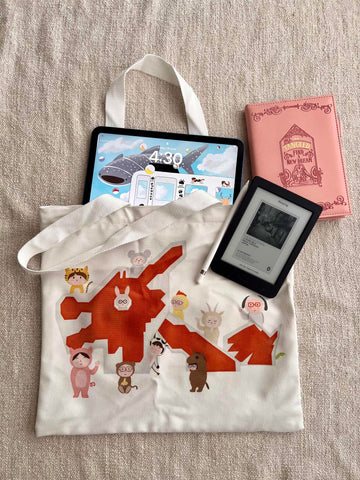 The image shows a cotton tote bag with illustration of Singapore's famous dragon playground. There are children dressing up in Chinese zodiac animals, i.e. bunny, tiger, rat etc) surrounding the playground, featuring the 12 Chinese zodiacs 