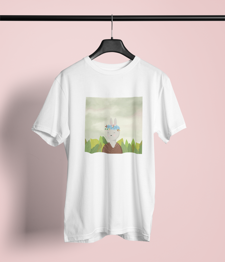 The image shows a white graphic t-shirt. The graphic on the t-shirt is a whimsical twist of Frida Kahlo's self portrait. The protagonist is a bunny, instead of the artist herself. 