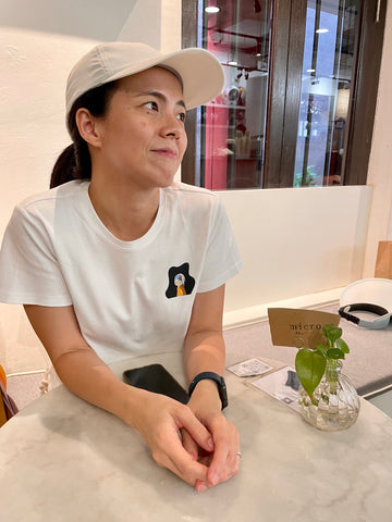 A lady wearing a white graphic T-shirt with a small illustration located at the left chest. The design is a whimsical twist on Johannes Vermeer’s ‘Girl with a Pearl Earring,’ featuring a bunny wearing pearl earrings. The image is cute and subtle